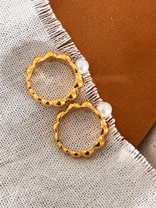 Detail of two French vintage gold rings with freshwater pearls on elegant fabric