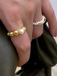Detailed shot of two vintage style rings with freshwater pearls on a gold metal band
