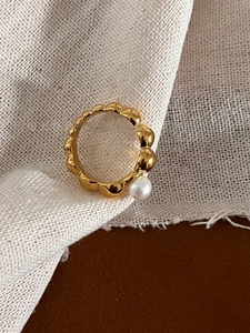 Detailed macro view of a vintage gold beaded band ring with a white freshwater pearl
