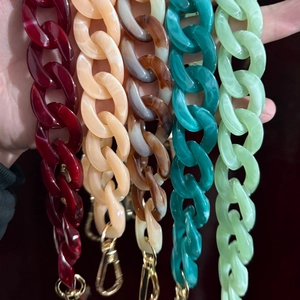 Close-up of colorful acrylic chain straps with golden lobster clasps in various textures