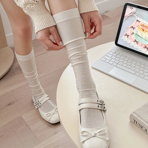 Elegant cream silk knee-high slouch socks with a soft knit texture and ribbed detailing