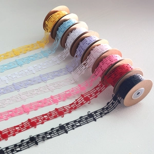 Close-up of musical note lace ribbons in eight vibrant colors on kraft paper spools