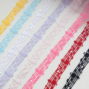 Macro shot of musical note lace ribbons in various colors with hollow woven details