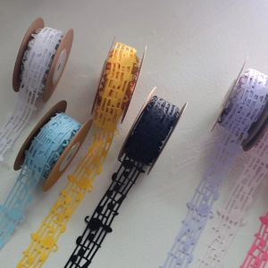 Close-up of decorative hollow musical note lace ribbons in various vibrant colors
