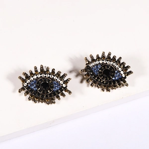 Retro evil eye stud earrings with blue crystals and bronze metal in a 45-degree view