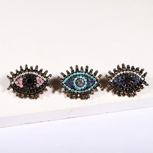 Macro shot of evil eye heart earrings with colorful crystals and vintage gold finish