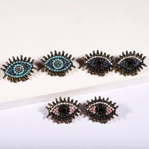Bohemian evil eye crystal earrings in blue and pink beadwork on a white display