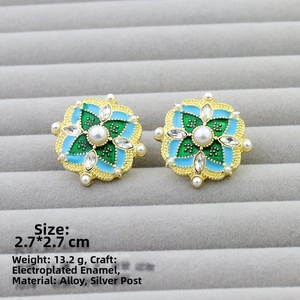 Detail of vintage flower earrings with blue enamel, pearl center and crystal accents