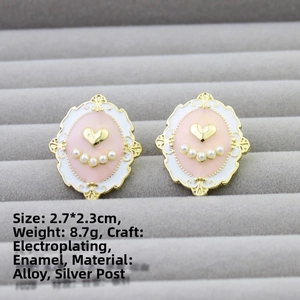 Detail view of pink and white enamel baroque stud earrings with gold hearts and pearls