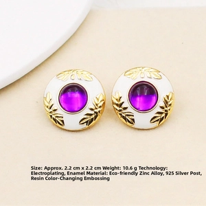 Detail of vintage round enamel earrings with gold leaf relief and purple cabochon center