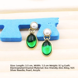Detail of vintage enamel drop earrings with pearl and emerald green acrylic charms