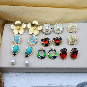 Vintage enamel earrings collection featuring faux rubies and pearls on gold silk background