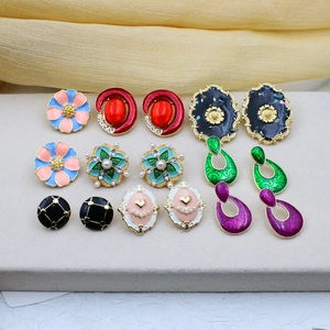 Retro enamel earring set with faux pearls and rhinestones on grey display board