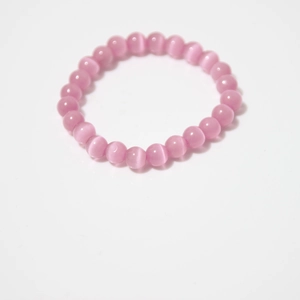 Close-up of pink cat eye stone beaded bracelet with 8mm round beads on white background
