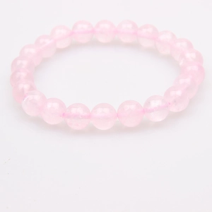 Close-up of translucent rose quartz crystal beads on an elastic bracelet
