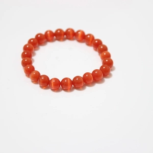 Detailed view of orange cat eye stone beaded bracelet with polished translucent beads