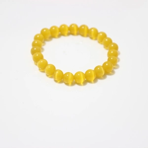 Detailed close-up of 8mm yellow cat-eye stone beads on a single strand stretch bracelet