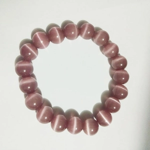 Detail shot of purple cat eye stone bead bracelet showing unique light reflection effects