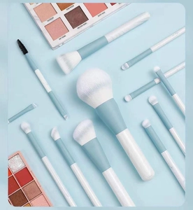 Detailed set of 12 sky blue makeup brushes with soft white bristles and ivory handles