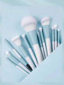 Detail of 12-piece soft makeup brush set with light blue handles and gradient bristles