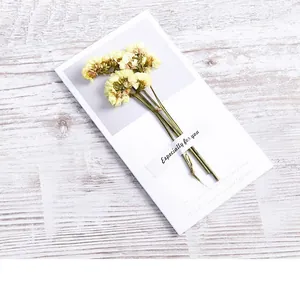 Close-up of handmade white card with real dried yellow flowers and 'Especially for you' text