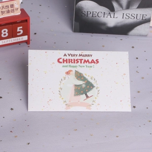 Close-up of a Christmas card showing a girl hugging a tree on a gold sequin background