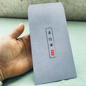 Macro shot of gray-purple matte envelope featuring traditional Chinese calligraphy