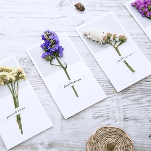 Dried baby's breath flower greeting cards for various occasions on a rustic wooden desk