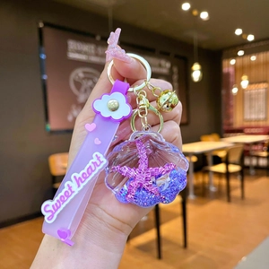 Macro view of purple shell keychain with glitter, stars, and Sweet Heart silicone strap