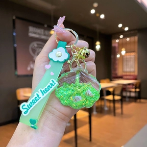 Detailed close-up of a shell-shaped liquid keychain with mint green sequins and beads