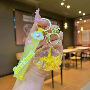 Detail of creative shell keychain with starfish glitter and yellow silicone heart strap