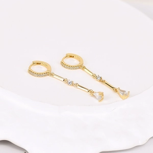 Détail du poinçon S925 sur boucles d'oreilles pendantes dorées avec oxydes de zirconium