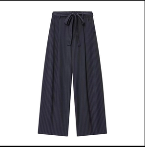Detail of navy blue pinstripe wide-leg trousers featuring a stylish waist tie bow