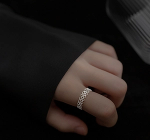 Close-up of S925 sterling silver lace ring with hollow heart patterns on woman's finger