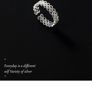 Macro shot of silver open ring featuring intricate lace hollow heart-shaped lattice design