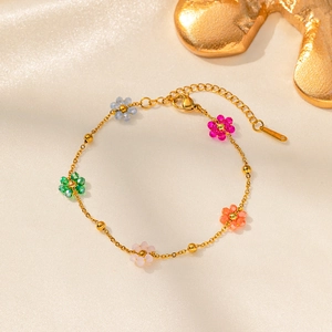 Golden flower beaded bracelet with colorful crystals on soft beige silk fabric