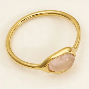 Gros plan d'une bague minimaliste en acier doré avec une pierre de quartz rose