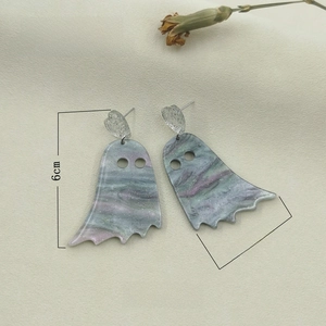 Macro view of ghost-shaped earrings with blue-purple marble texture and sequins