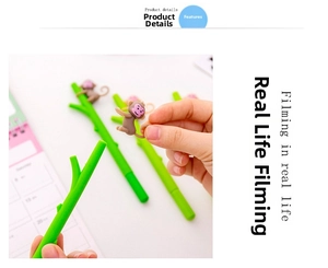 Detailed close-up of a green branch-shaped pen with a cute brown monkey charm detail