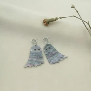 Ghost acrylic earrings with marble texture and silver heart stud on beige fabric