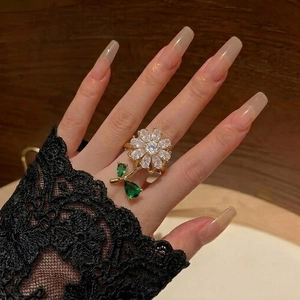 Rotating daisy sunflower ring with white zircon petals and green leaves on hand