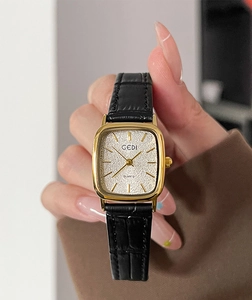 Vista macro di un orologio da donna quadrato vintage con cassa dorata e cinturino in pelle
