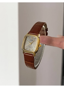 Dettaglio dell'orologio GEDI quadrato dorato con cinturino in pelle di coccodrillo