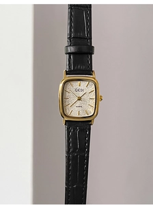 Dettaglio dell'orologio GEDI dorato con cinturino in pelle nera e quadrante con texture