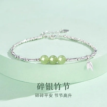Detailed shot of silver bamboo joint bracelet with green beads and small leaf charm