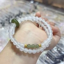 Double-layer beaded white jade bracelet featuring a green donut charm and gold spacers