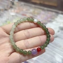 Detail of natural green jadeite beaded bracelet with colorful stone accents on a wrist