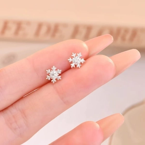 Macro shot of 925 sterling silver snowflake stud earrings with sparkling cubic zirconia