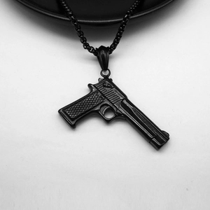 Detailed macro view of a black desert eagle pistol pendant with fine grid textures