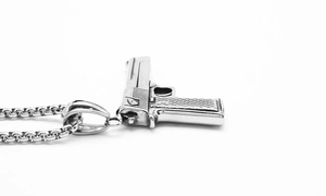 Detailed macro view of silver punk pistol pendant necklace with a textured grip
